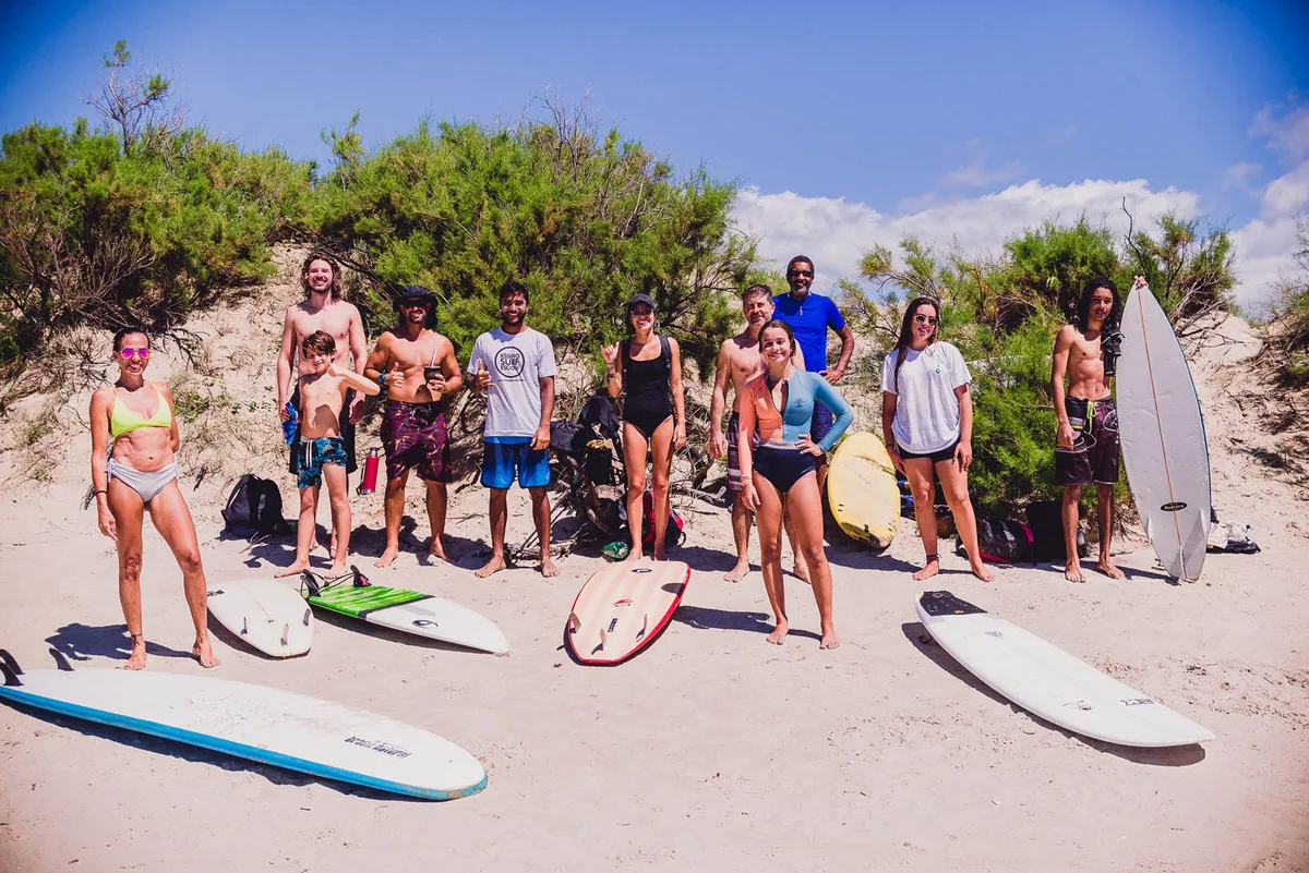Turma de adultos da Kssino Surf Escola com as pranchas, nas dunas do Cassino